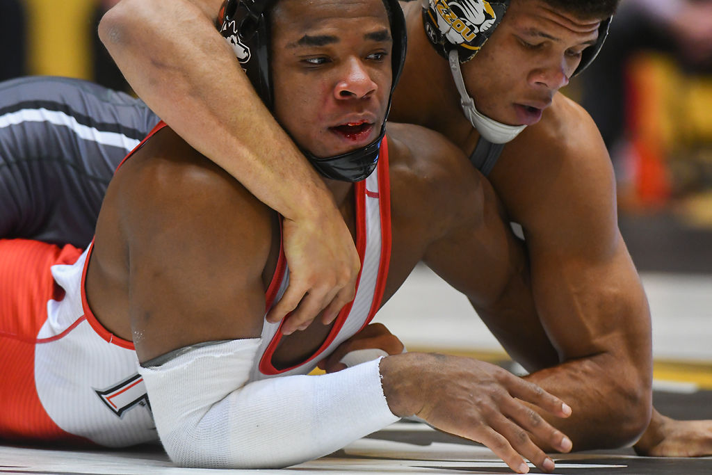 Northern Illinois' Kenny Moore's mouth bleeds during his match against Jeremiah Kent